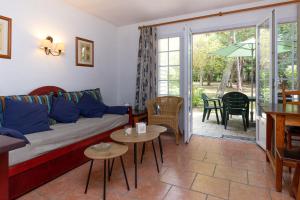 a living room with a couch and a table at Villa au coeur du golf in Moliets-et-Maa