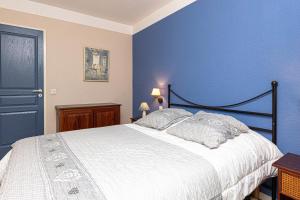 a bedroom with a bed with a blue wall at Villa au coeur du golf in Moliets-et-Maa +14 photos