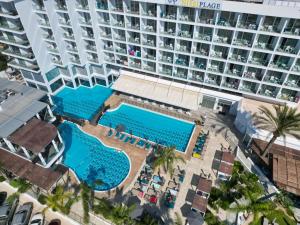 una vista aérea de una piscina del hotel con un gran edificio en Vassos Nissi Plage Hotel & Spa en Ayia Napa