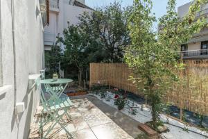 a small backyard with a table and a fence at Evergreen mansion in Alexandroupoli