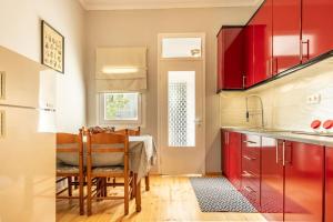 a kitchen with red cabinets and a table with chairs at Evergreen mansion in Alexandroupoli