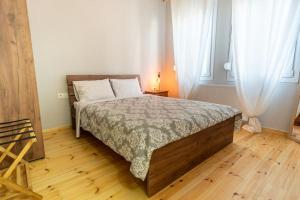 a bedroom with a bed and a wooden floor at Evergreen mansion in Alexandroupoli