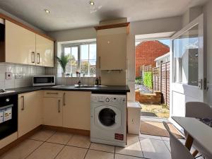 a kitchen with a washer and a sink and a dishwasher at Layla's Place in Hertfordshire in Chesfield