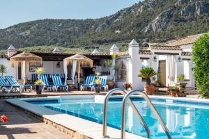 a villa with a swimming pool and mountains in the background at Pasa Fina, luxury holiday retreat in Villanueva del Trabuco