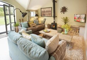 uma sala de estar com um sofá azul e uma mesa em The Gardener's Bothy em Shifnal