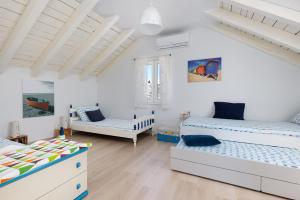 a white room with two beds and a couch at Holiday Home Bezic in Grohote +106 photos