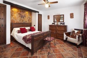 a bedroom with a bed and a dresser and a chair at Pasa Fina, luxury holiday retreat in Villanueva del Trabuco