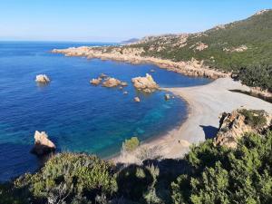 a view of a beach with rocks in the water at Bilocale 1 medio Trinita' D'agultu in Trinità d'Agultu e Vignola