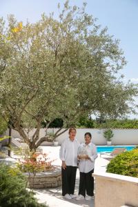 Residence Pietre d'Istria - with private service في Burići: شخصان يقفان بجانب بعضهما تحت شجرة