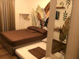 a small room with a bed and a mirror at La Reina Suite Tuscania Towers in Cagayan de Oro