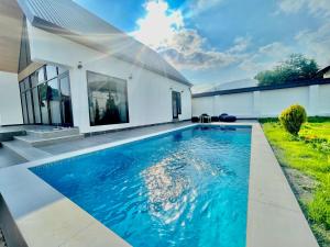 a swimming pool in the backyard of a house at EMIREST Barnhouse in Gabala