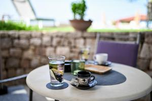 une table avec un verre d'eau et deux tasses dessus dans l'établissement Villa Hrešć S, à Zadar