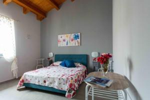 Un dormitorio con una cama y una mesa con flores. en Affittacamere Parisi, en Villaggio Mosè