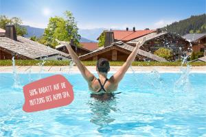 una donna in una piscina con un cartello in acqua di BergBuddies - Übernachtung inklusive kostenlosen Bergbahntickets und vielem mehr a Bad Hindelang