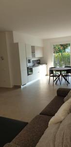 een woonkamer met een tafel en een keuken bij Claudia Apartment Peschiera in Peschiera del Garda