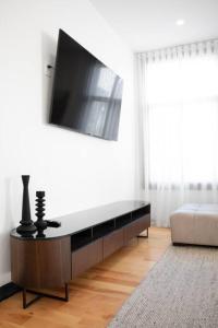 a living room with a flat screen tv on a wall at Upscale 3-Bedroom Entire Unit in the Trendy Plateau Mont-Royal featuring A Magazine-Worthy Kitchen & Opulent Living Spaces - Apt 1 in Montréal