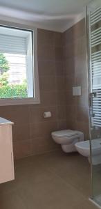 een badkamer met een toilet, een wastafel en een raam bij Claudia Apartment Peschiera in Peschiera del Garda