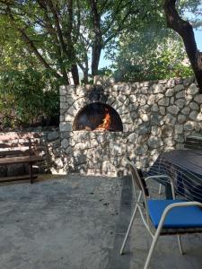a stone wall with a fire oven in a patio at Apartments Novak in Klenovica