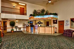 twee mensen staan aan een balie in een hotellobby bij Arch Canyon Inn in Blanding