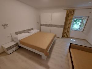 a bedroom with a large bed and a window at Apartments Novak in Klenovica