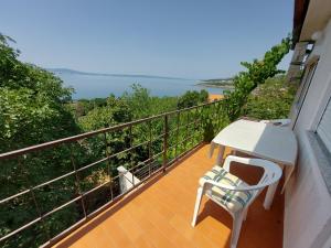a balcony with a white table and chairs and a view at Apartments Novak in Klenovica
