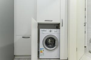 uma máquina de lavar e secar roupa numa lavandaria branca em JAD - Comfortable Family Apartments - Coresi em Braşov