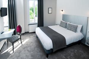 ein Schlafzimmer mit einem Bett, einem Schreibtisch und einem Stuhl in der Unterkunft Logis Hotel Restaurant Nougier in Saint-Étienne-de-Fursac