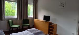 a bedroom with a bed and a tv and two chairs at Weingut Fehres in Brauneberg