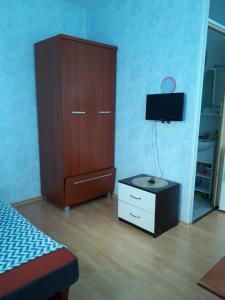 a bedroom with a bed and a dresser with a television at Vila Roz in Mangalia