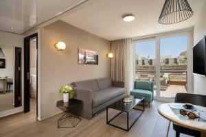 a living room with a couch and a table at Astral Palma Hotel in Eilat