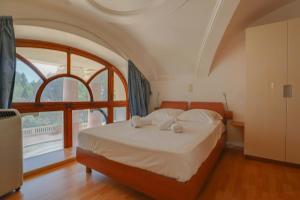 a bedroom with a bed and a large window at "Le Winter Palace" Prestigieux, Centre, Calme in Menton