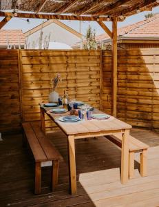 - une table et un banc en bois sur la terrasse dans l'établissement Villa Cocotte classée 4 étoiles à 150 m de la plage 4 chambres, à Biscarrosse