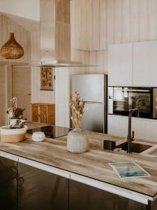 - une cuisine avec un comptoir en bois et un réfrigérateur dans l'établissement Villa Cocotte classée 4 étoiles à 150 m de la plage 4 chambres, à Biscarrosse