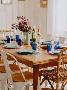- une table en bois avec des assiettes bleues et des verres à vin dans l'établissement Villa Cocotte classée 4 étoiles à 150 m de la plage 4 chambres, à Biscarrosse