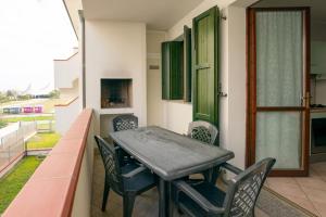 una mesa y sillas en el balcón de una casa en Residence Smith Sul Mare en Lido degli Estensi