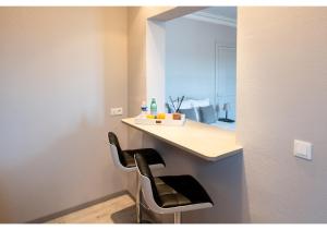 a small kitchen with two chairs and a counter at L'haussmannien, hyper centre 2 min à pied in Évreux