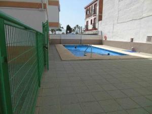 a swimming pool in a building with a green fence at A&N Nevada 76 in Torre del Mar
