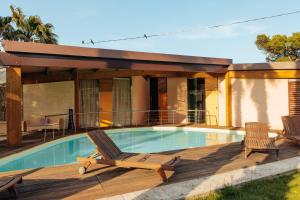 a swimming pool with two lounge chairs next to a house at Relax in Vieste