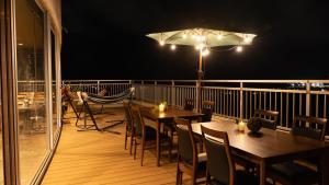 balcón con mesas, sillas y sombrilla en Rycom Crystal Hotel en Okinawa City