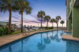 una gran piscina con palmeras y sillas en Navy Cove 1405 en Gulf Shores