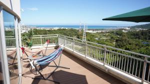 a couple of chairs sitting on a balcony with the ocean at Rycom Crystal Hotel in Okinawa City