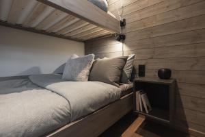 Ce lit se trouve dans un dortoir doté de murs en bois. dans l'établissement Fjällparadiset Lindvallen, à Sälen