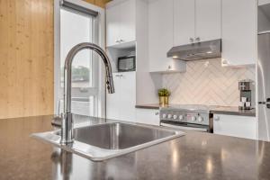 a kitchen with a stainless steel sink and a stove at Initial / Artsy / Centre ville de Quebec in Quebec City