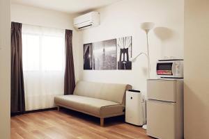 a living room with a couch and a microwave at RAKUTO通天閣301 特價2室1厅,日本橋難波心斎橋1站, 車站3分,緊鄰通天閣, 直達關西機場大阪城USJ京都. in Osaka