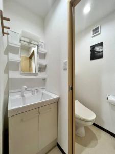 a white bathroom with a sink and a toilet at RAKUTO通天閣301 特價2室1厅,日本橋難波心斎橋1站, 車站3分,緊鄰通天閣, 直達關西機場大阪城USJ京都. in Osaka +15 photos