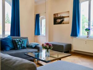 ein Wohnzimmer mit einem Sofa und einem Tisch in der Unterkunft Residenz am Dresdner Stadtwald in Dresden