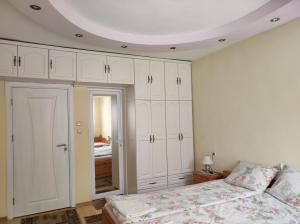 een slaapkamer met witte kasten en een bed bij Family Hotel Velevi in Velingrad