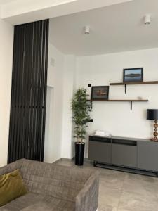 een woonkamer met een bank en een tafel bij Apartament LOFT in Ostróda