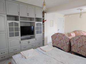 a living room with a couch and a television at Family Hotel Velevi in Velingrad +42 photos