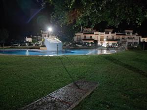uma piscina à noite com luz em Dúplex Casa Ana Apartaclub La Barrosa em Chiclana de la Frontera